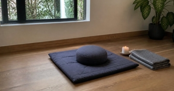 Meditationsmatte mit Kissen im ruhigen Zimmer